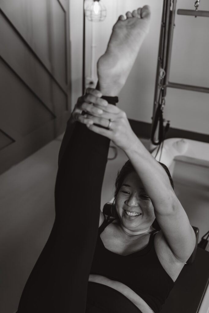 pilates instructor on reformer stretching